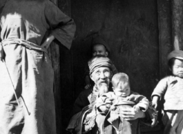 Village elders holds child in Yangkai village.  From the collection of Frank Bates.