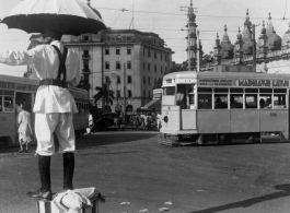 Traffic policeman directs traffic as trams go by.  Scenes in India witnessed by American GIs during WWII. For many Americans of that era, with their limited experience traveling, the everyday sights and sounds overseas were new, intriguing, and photo worthy.