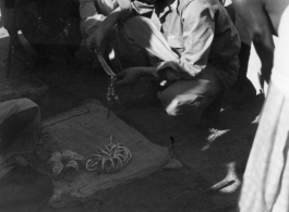 A GI negotiates for metal jewelry in India.  Scenes in India witnessed by American GIs during WWII. For many Americans of that era, with their limited experience traveling, the everyday sights and sounds overseas were new, intriguing, and photo worthy.