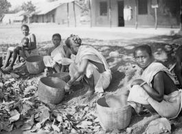 Women doing something with baskets.  Scenes in India witnessed by American GIs during WWII. For many Americans of that era, with their limited experience traveling, the everyday sights and sounds overseas were new, intriguing, and photo worthy.