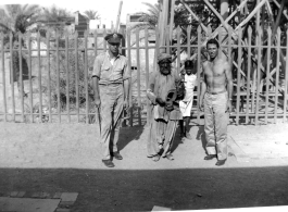 GIs pose with musician and child.  Scenes in India witnessed by American GIs during WWII. For many Americans of that era, with their limited experience traveling, the everyday sights and sounds overseas were new, intriguing, and photo worthy.