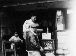 GI shops at a small shop.   Scenes in India witnessed by American GIs during WWII. For many Americans of that era, with their limited experience traveling, the everyday sights and sounds overseas were new, intriguing, and photo worthy.