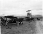 A pair of Stinson L-5's at a base in China, possibly Yangkai.  Notice the man in the background starting the plane, and the simplified control tower.