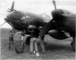 The P-38G Lightning fighter plane "Golden Eagle" (#42-13437 ) gets another bomb emblem after another mission, while Chinese guard keeps watch. #7871  Piloted by Capt Billie Beardsley.  This plane was a member of the 51st Fighter Group 449th Fighter Squadron "Twin Tailed Dragons"(thanks  jbarbaud).