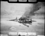 A P-38 fighter destroyed on the ground by a bombing.