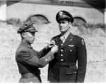 1st Lt. Robert L. Logan stands at attention as ta Chinese Air Force staff officer adjusts his new Chinese Air Force Wings. Lt. Logan received his wings based on his service in CACW, as a leader of the "Spray and Pray Squadron."