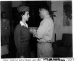 1st Lt. Addie Newland, an Army Nurse assigned to the Medical Air Evacuation Squadron, receives Air Medal from General. C. L. Chennault in the CBI during WWII.