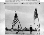 Flag raising ceremony at Nanning Air Base, China, on 8 July 1945, after its re-occupation by the Allies. Sgt. Edward F. Rossler hoists American flag, while a Chinese interpreter raises Chinese Nationalist flag.