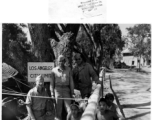 GIs pose with squatting men in the CBI, likely Japanese POWs.  Photo processed by 164th Signal Photographic Company.