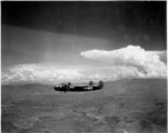 A 491st Bomb Squadron B-25H, tail #439, in formation flight somewhere over China. Look carefully above the tail to see two more B-25s just below the large cloud.