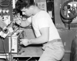 An American serviceman works on electrical equipment in an aircraft in the CBI during WWII.  This image was scanned at high resolution from the original negative and the clarity and detail is exceptional. the white box in the upper right corner is labelled "Desiccated Normal Human Plasma," testifying to the deadly seriousness of the business of these aircraft and their crews.