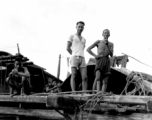 Chinese men on a wooden structure give a curious smile for the photographer, China.  From the collection of Wozniak, combat photographer for the 491st Bomb Squadron, in the CBI.