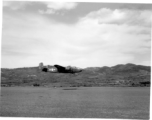 A B-25 Mitchell bomber races by close to the ground, at Yangkai (Yangjie) air strip in Yunnan province, China.