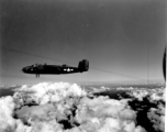 B-25 Mitchell bombers in flight in the CBI, in the area of southern China, Indochina, or Burma. Notice the group further away against clouds at the bottom of the image.