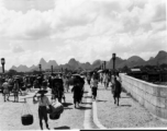 Bustling city life on a bridge in Guilin during WWII.