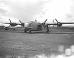 The Consolidated B-24 bomber "Nip Nipper," serial #42-72837. This is later in the war, and the B-24 has been modified to carry cargo, with the nose guns (and much more) removed. Note the aircraft wing on blocks to the left, and the salvaged C-47 fuselage in the background. During WWII, in China.