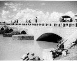 Nationalist soldiers (plus possibly one GI) lounge on the bridge at Luliang. During WWII.