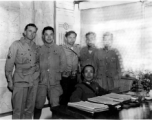  A very emaciated and wary-looking Zheng Tingji (郑庭笈), commander of the 48th Army Division (陆军第四十八师 ), poses at his desk in Yunnan, with GIs and more junior Chinese officers. Eugene T. Wozniak, arms around Chinese comrades, standing in the middle.