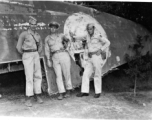 GIs pose against downed aircraft wing. The middle person might be Maj Richard D. Day (李察戴).