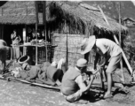 Stretcher bearers take a break in Guangxi province, either Guilin or Liuzhou area, probably during the evacuation of fall 1944. The white paper posted on the store sign says basically, "Everything for sale, including building, animals, possessions."