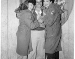 Celebrities visit and perform at Yangkai, Yunnan province, during WWII: Happy GI poses with two starlets 0n the stage at Last Resort.