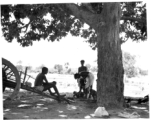 Man undergoes country haircut under tree.  Scenes in India witnessed by American GIs during WWII. For many Americans of that era, with their limited experience traveling, the everyday sights and sounds overseas were new, intriguing, and photo worthy.