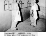 Two patients at the Convalescent Camp (#3) in Kunming, China, look with anticipation at the shower rooms being erected for their comfort. Two shower rooms are nearing completion, each having 6 showers and a large adjoining washroom. The buildings are of brick and will have both hot and cold water.  June 19, 1945.  Photo by T/4 Louis Raczkowski. 