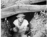 Engineer of the 797th Engineer Forestry Company poses in an old bunker with discarded Americans mortar shells in hand, similar to US M49A2 60MM mortar.  During WWII.