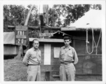 Engineers of the 797th Engineer Forestry Company pose before bulletin board on Friday the 20th, in Burma. On bulletin board is posted a "Buck Sheet," a two page paper printed for GIs in the area. During WWII.