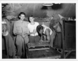 Engineers of the 797th Engineer Forestry Company pose while playing at a tiny pool table in their tent in Burma.  During WWII.