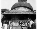 People in front of temple-like building in Burma or India, possibly looking at wrapped body.  Near the 797th Engineer Forestry Company.  During WWII.