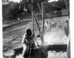 Local people in Burma near the 797th Engineer Forestry Company--A woman gets water in Burma.  During WWII.