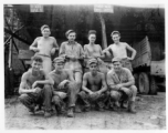 Engineers of the 797th Engineer Forestry Company pose outside truck repair garage at camp in Burma.  During WWII.