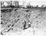GIs examine giant bomb crater in Burma.  During WWII.  797th Engineer Forestry Company.