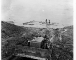 Cat pulling logs raft up bank from river.  797th Engineer Forestry Company in Burma.  During WWII.