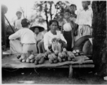 A woman sells cucumbers or something similar in Burma.  Local people in Burma near the 797th Engineer Forestry Company.  During WWII.