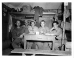 Engineers of the 797th Engineer Forestry Company pose in their barracks in Burma. Note the canned bacon on the shelf behind.  During WWII.