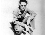 American flyer Tom Zera kneeling on ground.  22nd Bombardment Squadron, in the CBI.