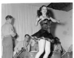 Tap dancer at a USO show in Gushkara, India, during WWII.  The boxes in front of the band players are labeled 748th ROB (748th Railway Operating Battalion).