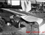 A Chinese refugee resting and hiding from the heat near a train at Liuzhou during the evacuation in Guangxi during the fall of 1944. 