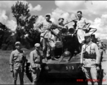 Chinese crew and American GIs aboard Chinese armored vehicle or tank pose for a photo. The vehicle was likely out on a large scale military exercise.  From the collection of combat photographer Eugene T. Wozniak, 491st Bomb Squadron.