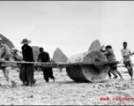 Chinese workers pulling a large roller at a base  in Guangxi province (probably Liuzhou, but maybe Guilin), China. 