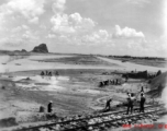 An airstrip under construction near a railroad, in a region of karst formations.  This is almost certainly Liuzhou, in Guangxi province.