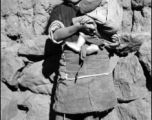 A girl holds a child. Local people in China, probably in Yunnan province.  From the collection of Wozniak, combat photographer for the 491st Bomb Squadron, in the CBI.