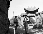 A photographer walking the paths of a village in Yunnan province stops to engage a Chinese soldier.