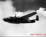 491st Bomb Squadron aircraft #438, a B-25J appears smooth in formation flight in spite of large, turbulent clouds filling the China sky behind it. Notice the barrels of three .50 caliber machine guns sticking out of the nose of the aircraft. One is a flexible gun, used by the bombardier or navigator to defend the nose from attack.  The other two are hard mounted to the lower, right side of the bombardier's area. The pilot fires them simultaneously with four mounted to the sides of the aircraft for straffing