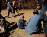 An infant with a colorful hat sitting.  At a rural village near the American base at Yangkai, Yunnan province, in the CBI.