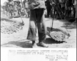 Young girl shoulders carrying-pole to repair runway at Liuzhou, Guangxi province, in the CBI, after Japanese retreat after Ichigo.