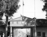 The entrance to a Nationalist government facility in Yunnan province, China.  Above the gate is a slogan, "Be faithful to the party, be patriotic." During WWII.