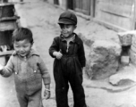 Local kids in China: Boy and girl on the side of the street in SW China during WWII.